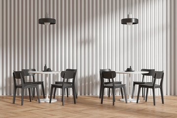 A modern minimalist cafe interior setup with black chairs, round tables, pendant lights, wood flooring, and a striped wall. 3D Rendering