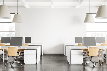 Fototapeta premium Modern coworking interior with pc desktop on tables and window. Mockup wall