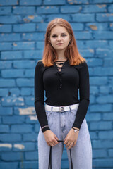 Portrait of a young beautiful red-haired girl in a summer park.