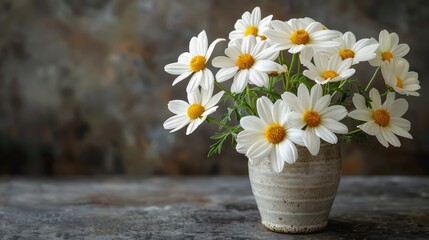   A vase brimming with white and yellow blooms atop a wooden table beside a brown-and-white wall
