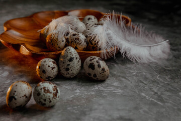 Wooden plate with quail eggs on a gray background