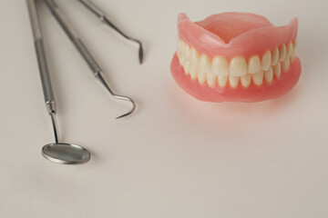 Dentures and dentist tools on a white background with copy space - 778760313
