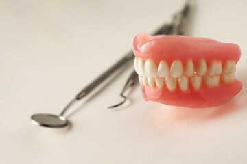 Dentures and dentist tools on a white background with copy space - 778760339