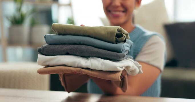 Laundry, clothing and woman holding pile of washing, smile and finished household chores. Hands, folding or fabric for spring clean in home, housewife or housekeeper for sanitary hygiene or organize