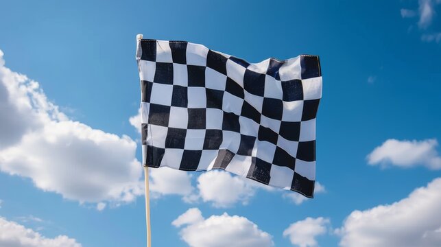 Waving checkered flag against blue sky background. 