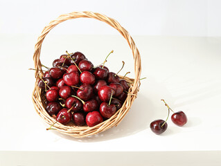 A basket of fruit cherries on a white tabletop
