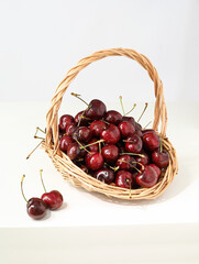 A basket of fruit cherries on a white tabletop