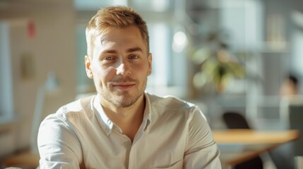 Fototapeta premium Professional looking young man smiling in a bright office environment