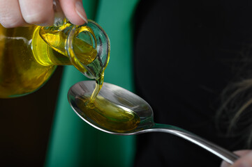 Nalewać olej ze szklanej butelki na łyżeczkę z bliska