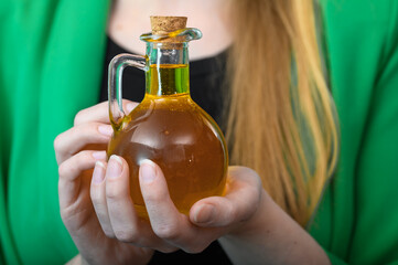 Kobieta trzyma butelkę ze świeżym olejem