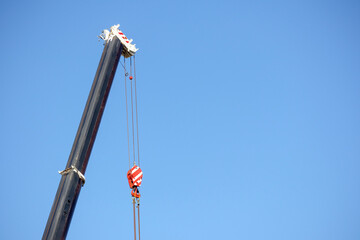 
Road crane with a hook in it on a blue sky background