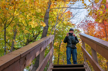 Tourist taking photos on the hiking track among autumn colours. Mont Tremblant. Quebec. Canada. - 778774916