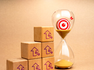 Business success process and marketing goals plan concepts. 3d Target icon in hourglass near wooden cube blocks growth graph steps with rising percentage arrow symbols, minimal background.