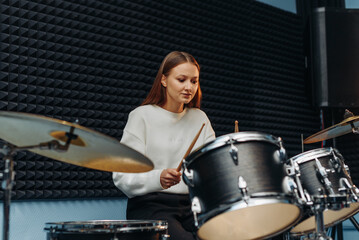 Obraz na płótnie Canvas young woman playing drum set
