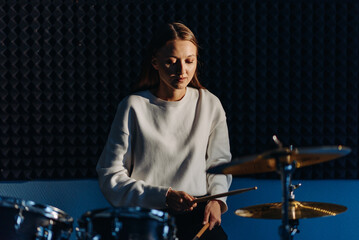 Fototapeta na wymiar young woman playing drum set
