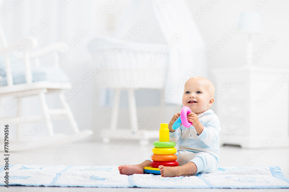 Wall mural baby playing with toy pyramid. kids play