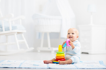 Baby playing with toy pyramid. Kids play - 778790516
