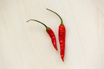 Hot red chili or ripe chilli pepper isolated on wooden background.