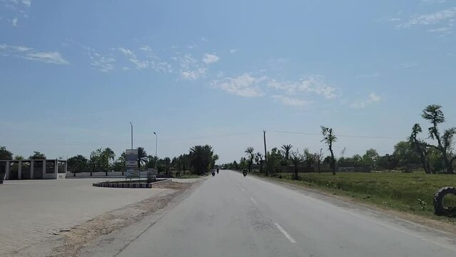 Profile of roads and green trees with cloudly blue sky.
Leh Kot Addu Road, Pakistan. Beautiful 4K footage.