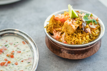 Spicy Indian biryani pulao in golden bowl with India basmati rice dish with chicken meat curry