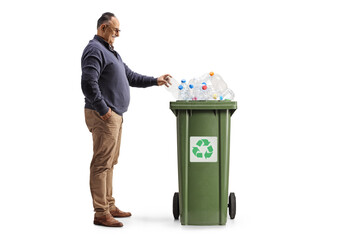 Full length profile shot of a mature man throwing a plastic bottle in a recycling bin