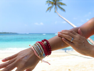 Woman hand with sunscreen cream on the sand beach as applying moisturizing lotion on .Skin care...