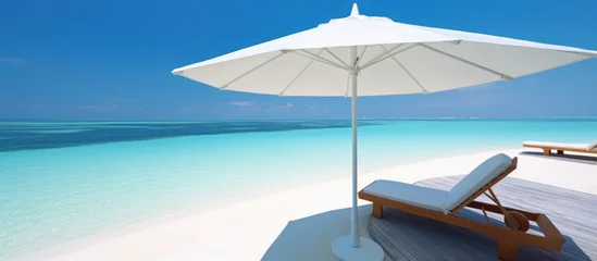 Fotobehang beautiful white parasol and sunbed in sea tropical Maldives romantic atoll island paradise luxury resort about coral reef amazing © SULAIMAN