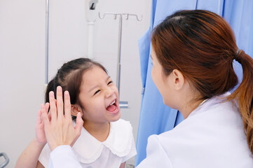 A female doctor and a young patient smile encouragingly. Pediatrician concept.