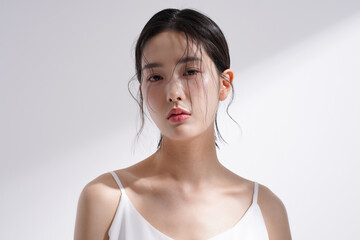 光と影の背景で撮影をした若い韓国人女性の美容イメージ写真