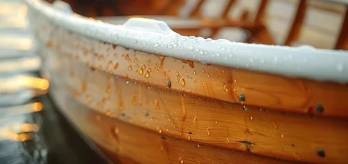 Fotobehang   A close-up of a wooden boat with water droplets on its side and rows of chairs in the background © Igor
