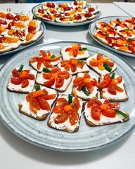 crackers spread with soft cheese with cut Cherry tomatoes in the shape of a flower, decorated with pieces of orange bell pepper. Snack for children. healthy food. holiday in kindergarten. plates