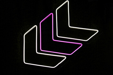 neon direction sign on black background