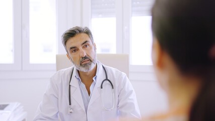 Doctor listening to a female patient in a clinic