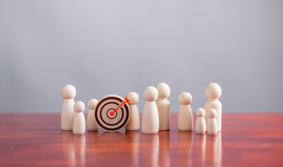 target and goal Business concept,Wooden figures standing around Dart board and arrows for targeting...