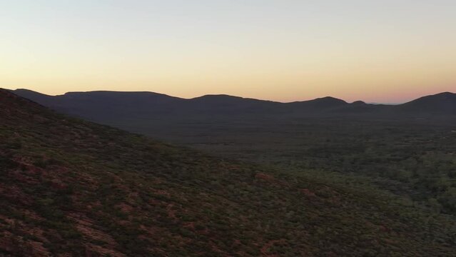 Dark sun lit peaks and ranges of Flinders Ranges Wilpena pound rocks aerial 4k.
