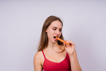 Close-up of a woman eating a sausage. Cropped photo in studio