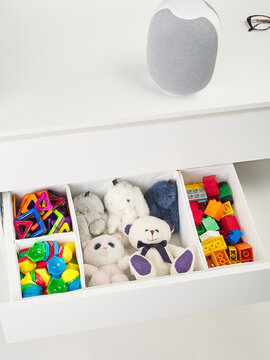 furniture cabinet with toys. open box with children's construction set. smart speaker