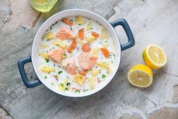 Serving pan with finnish salmon soup lohikeitto, above view on a grey granite background,...
