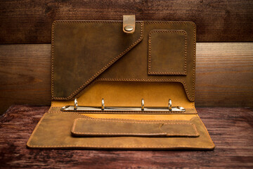 Cover folder made of genuine leather a notepad of papers size A5 on a dark wooden background.
