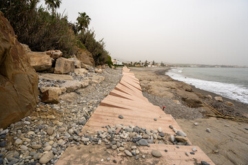 Playa y Mar Mediterraneo durante el invierno, camino destrozado por temporal