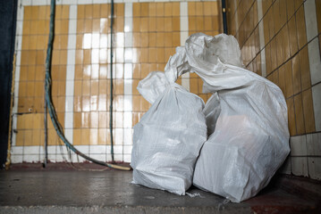 Trash bags on the dirty floor of construction site background. Industrial garbage.