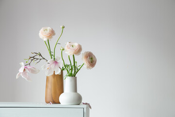 spring flowers in vases in white modern interior