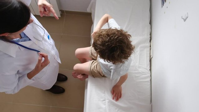 A neurologist examines a 6-year-old child with brain damage and neurological injuries.