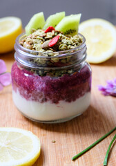 Strawberry and yogurt parfait topped with matcha granola in a jar and healthy oatmeal tart shell with raspberry jam with chia seeds 