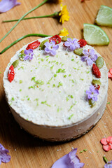 Raw lime cheesecake made from raw cashew nuts, honey, maple syrup, oat milk and lime topped with goji berries and pumpkin seeds 