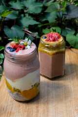 Passion fruit smoothie bowl and jar with  strawberry and bluberry topping 