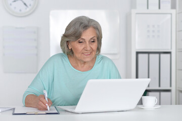 Senior business woman working in office with laptop