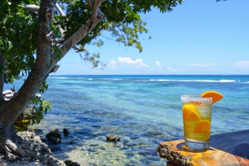 Obraz premium A vibrant beach scene with colorful summer cocktails resting on the sand, overlooking the azure sea