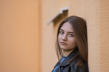 Fototapeta premium Portrait of a young beautiful long-haired girl in an urban environment.