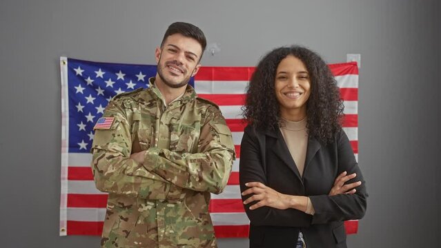 A confident woman in business attire and a man in military uniform with the united states flag in the background